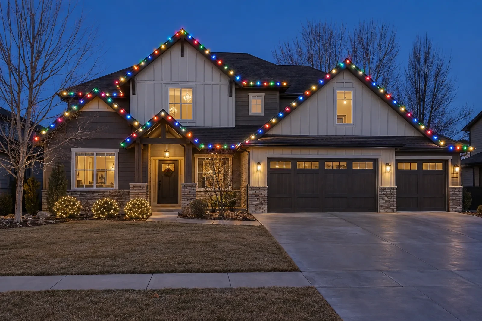 A two-story home with multicolor C9 lights on the roofline and gables and wrapped shrubs
