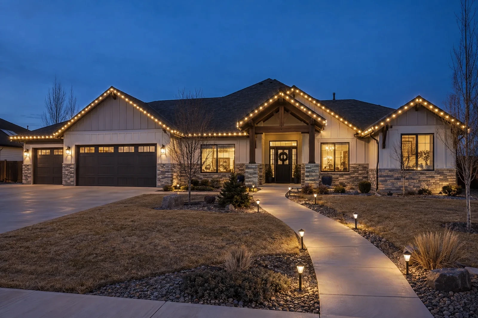 A wide single-story with roofline lights and lit stake lights down a curved walkway
